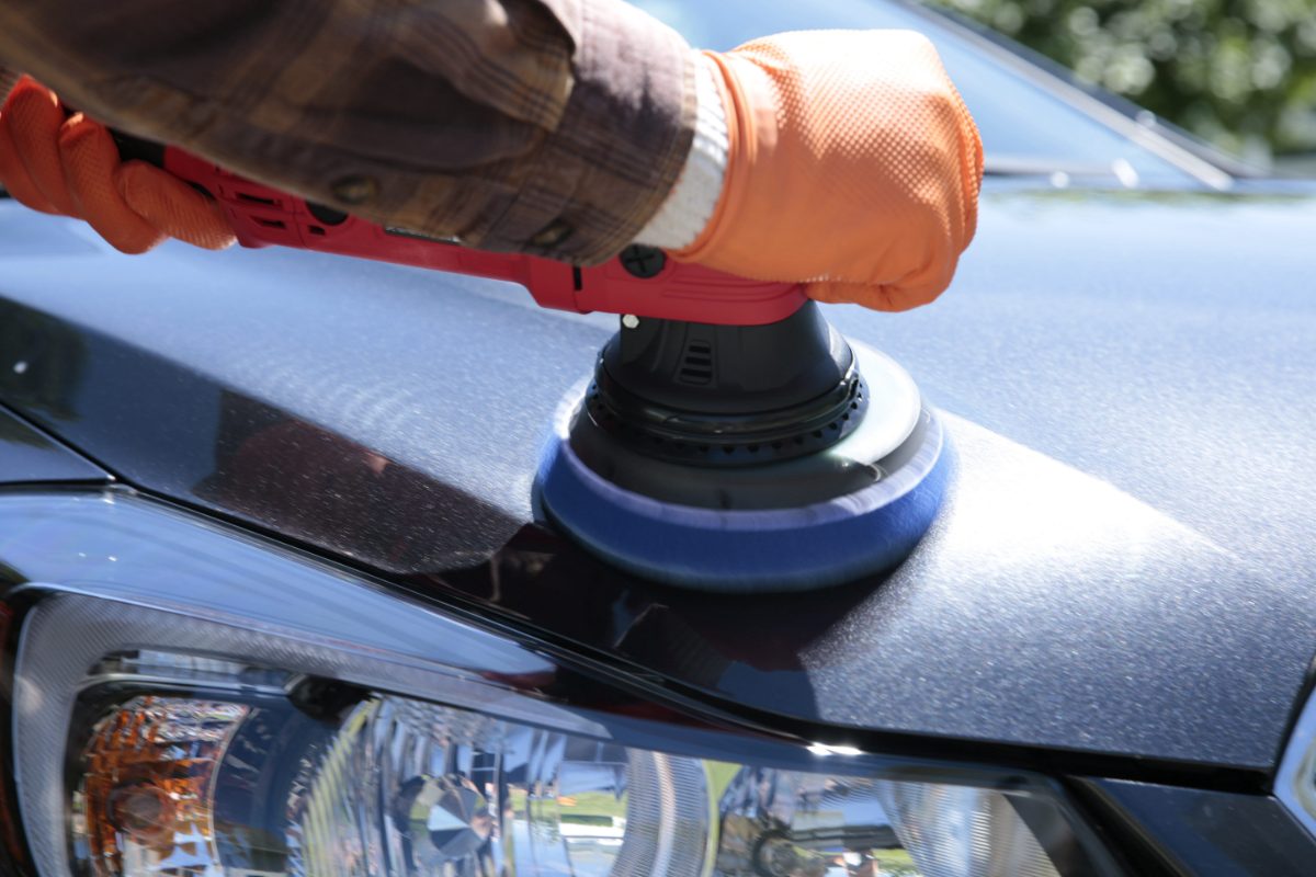 Machine polishing a car hood to restore gloss